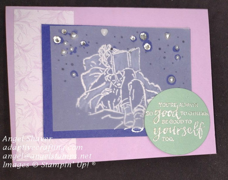 Purple card with heat embossed image of girl reading a book with a blanket and a dog.  Vellum covers the image and it topped with rhinestones and pearls The sentiment says "You're always so good to others, be good to yourself too."