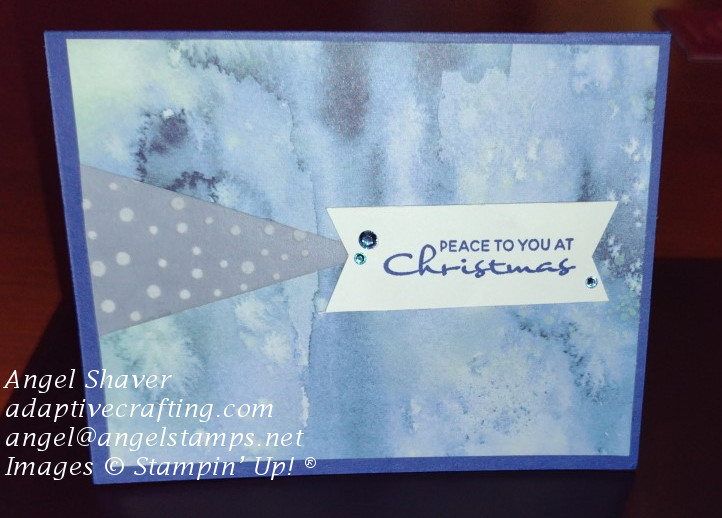 Blue Christmas card with patterned paper that looks like a snow storm.  Card has triangle of vellum with white dots and sentiment says "Peace to you at Christmas."
