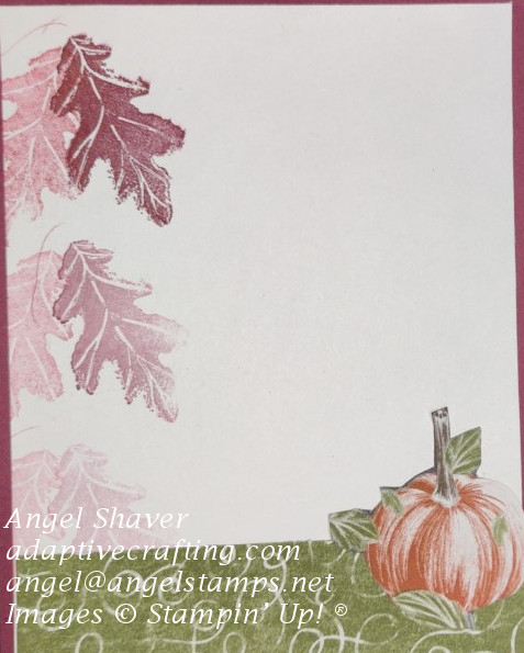 Inside of card with strip of green patterned paper at bottom of card with fussy cut pumpkin on right and stamped fall leaves on left side.
