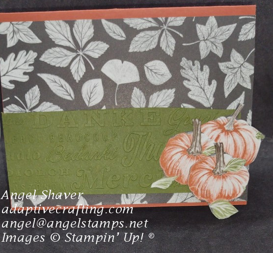 Fall themed thank you card with fall leaves patterned paper, embossed green cardstock strip saying thanks in lots of languages, and fussy cut pumpkins.