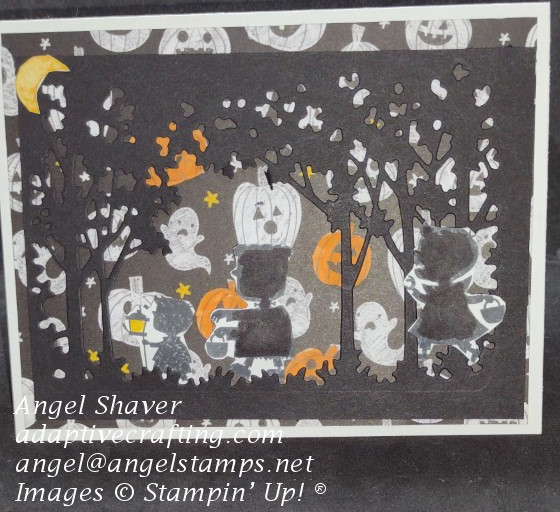 Halloween card with black grove silhouette with silhouette's of trick or treaters walking through the woods.  Background paper shows jack o lanterns, ghosts, and stars.