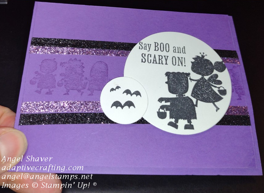 Purple Halloween card with monochrome stamped parade of trick or treaters.  Featured circle with trick or treaters.  Setiment says "Say Boo! and Scary On"