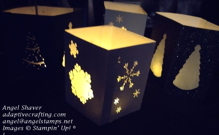 Christmas luminaries with snowflake or Christmas tree cut outs lit up in the dark.