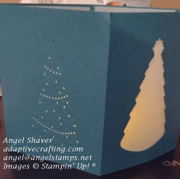Deep greenish turqoise paper Christmas luminary with die cut Christmas trees covered in vellum.