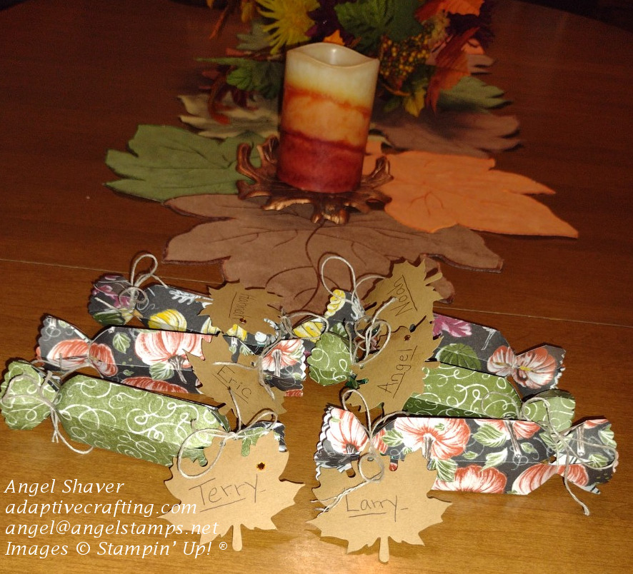 Treat cracker place cards made from fall themed pattern paper with a leaf tag tied on one end with a name on it.