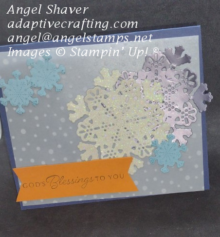 Navy Christmas card with vellum snowflake background.  Die cut snowflakes decorate front--large vanilla glimmer, large silver foil, small blue cardstock snowflakes.  Orange sentiment label reads, "God's blessings to you."