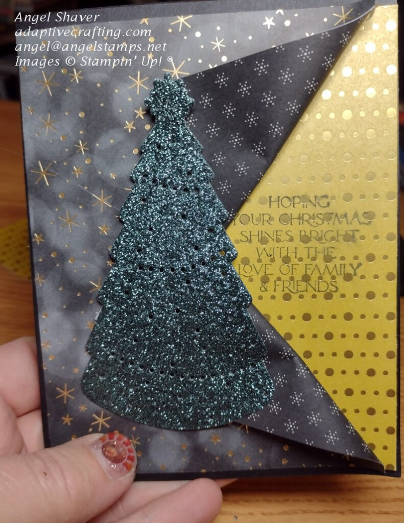 Peek a boo fun fold black Christmas card with gold foil peeking through the fold.  Featured a green sparkling Christmas tree die cut.  Sentiment says "Hoping your Christmas shines bright with the love of family & friends."