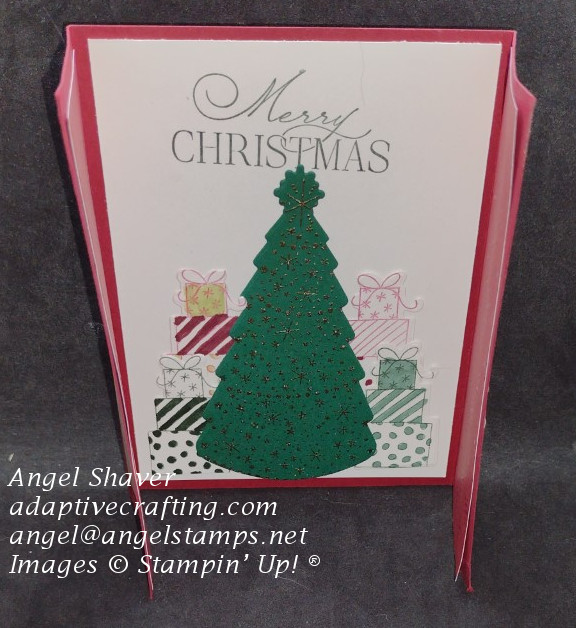 The gatefold card opens up to reveal a die cut Christmas tree with gold heat embossed ornaments surrounded by four piles of gifts.  Top of the card says, "Merry Christmas."