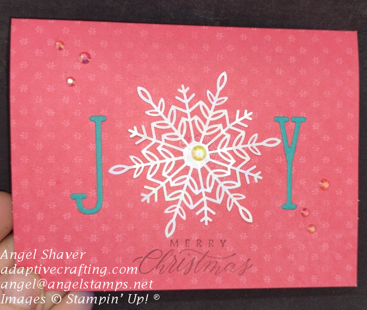 Red Christmas card with die cut joy.  Snowflake die represents the O in the word.  "Merry Christmas" is stamped at the bottom of the card front.  Iridescent Rhinestones add sparkle.