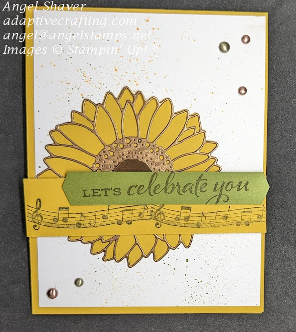 Yellow card featuring a die cut sunflower.  Yellow strip of cardstock with lines of music and green strip of cardstock saying, "Let's celebrate you." on top of sunflower.