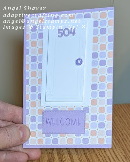 Purple card with pink and purple tile patterned paper layer.  Card has diecut of white door with purple numbers and doorknob with heart.  Purple welcome mat is in front of door
