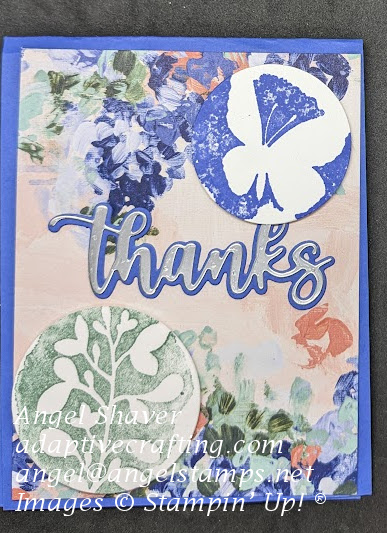 Blue card with patterned paper card front with flowers.  White butterfly with stamped blue background circle in top right.  White plant with stamped green background circle on bottom right.  Diecut thanks sentiment in center of card.