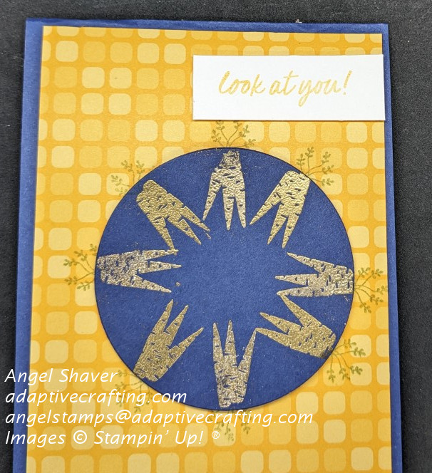Blue card with yellow and orange squares patterned paper front layer.  Blue circle contains 24 heat emboosed gold carrots .  Sentiment says, "look at you!"