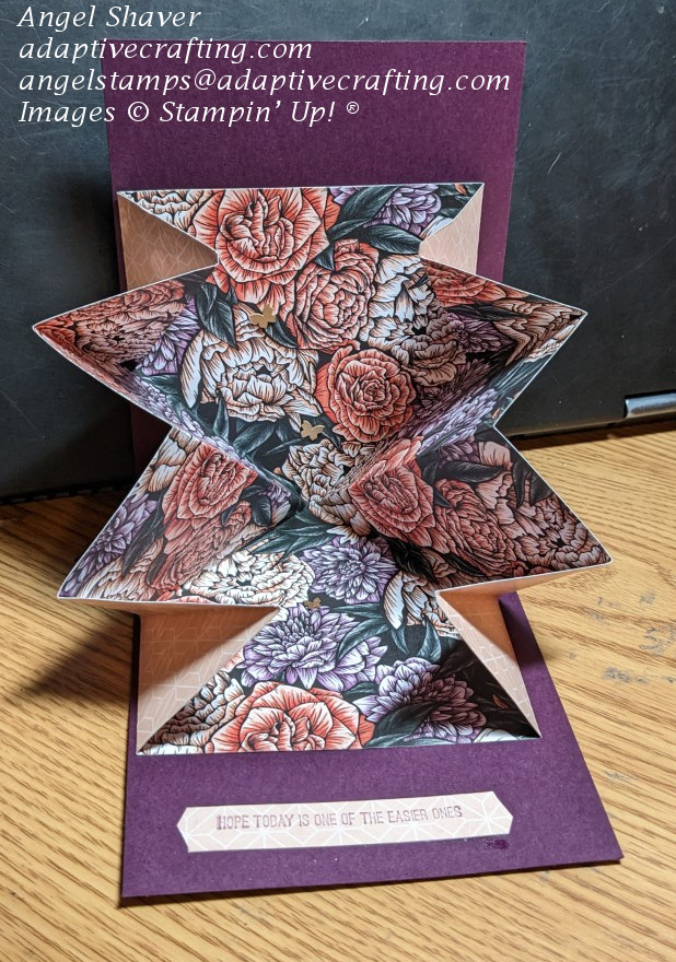 Inside of card with patterned paper "explosion" featuring lots of pink and purple flowers with three brass butterflies.  Sentiment label says, "Hope today is one of the easier ones."