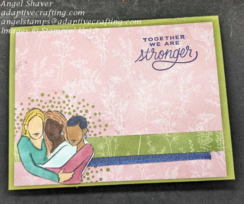 Green card with pink patterned card layer with floral patterns.  Strip of green floral paper and navy ribbon along lower half of card.  Half circle of dots diecut into card layer at bottom left.  Stamped and colored image of three female friends.  Sentiment says, "Together we are stronger."