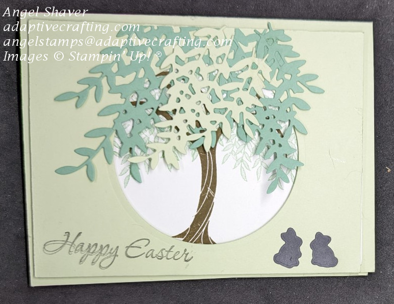 Light green easter card with cut out circle in the middle framing a stamped willow tree with die cut leaves.  Two easter bunny dies are at the bottom of the card.  Sentiment says, "Happy Easter."