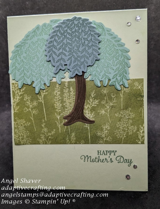 Green Mother's Day card with a strip of patterned paper featuring flowers. Card also has a die cut willow tree, rhinestones and sentiment that says, "Happy Mother's Day"