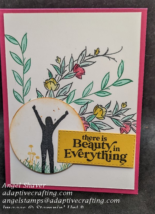 Pink card with floral and leafy stems stamped behind featured circle.  Featured circle had woman stamped in center with arms raised standing in grass beside flowers.  Sentiment says, "There Is Beauty in Everything."