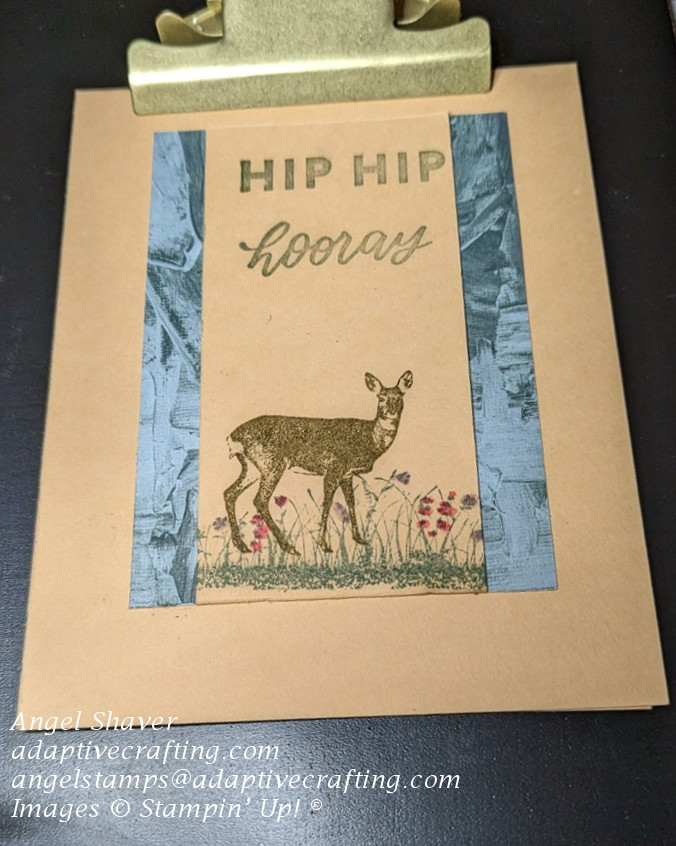 Peach card with peach strip framed by patterned paper in shades of green.  Center panel says "Hip Hip Hooray" and has deer standing in grassy field with flowers.