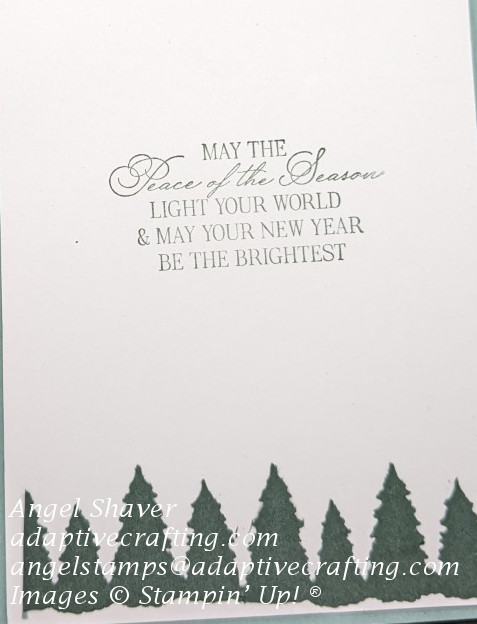 White inside of card with green everygreen tree border at the bottom of the card.  Sentiment says, "May the peace of the season light your world and may your new year be the brightest."
