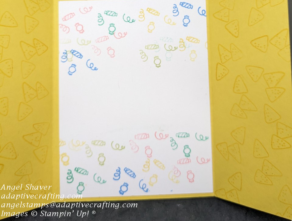 Open gatefold card with tone on tone yellow chips stamped on both side panels.  Center is white panel with streamers and candy stamped in lots of bright colors.