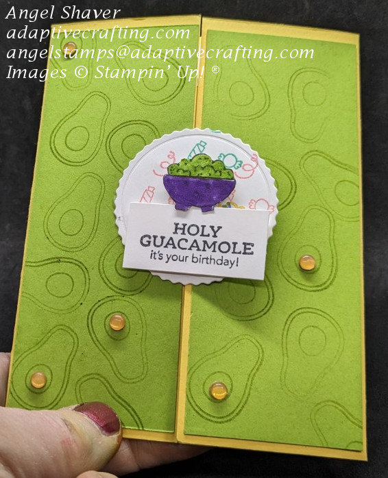 Yellow gatefold card with green panels on the front stamped tone on tone with avocados.  Circle die added to center, attached to one panel.  It is stamped with streamers and candy in bright colors.  Stamped bowl of guacamole die sits on top of the circle.  Sentiment says, "Holy Guacamole.  It's your birthday"