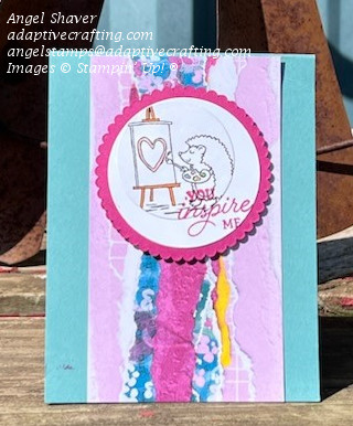 Teal card with strip of patterned paper that looks like torn strips of paper in light purple, hot pink, yellow, and blue flowers.  Paper is topped by layered circles with the bottom circle a hot pink scalloped circle and the top a circle with the image of a hedgehog painting on an easel.  Sentiment says, "You inspire me."