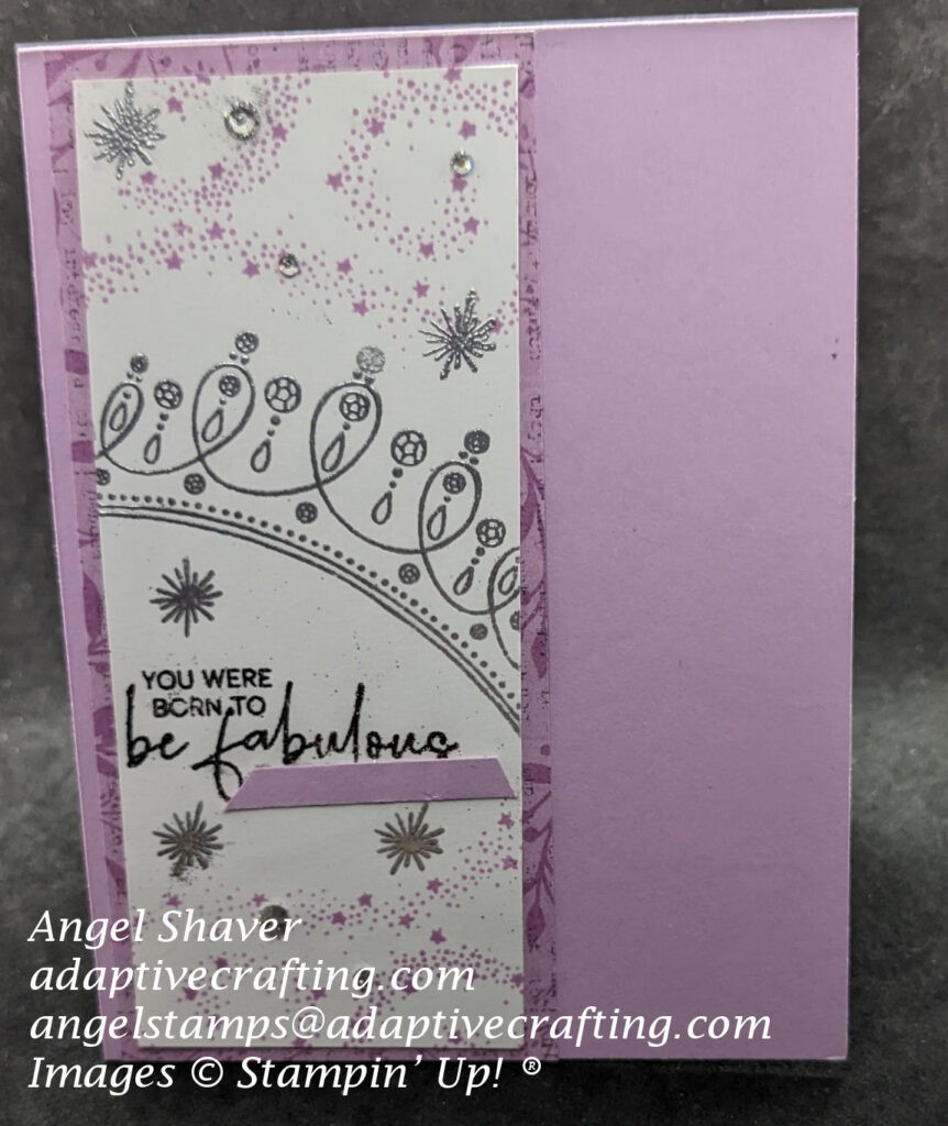 Purple card with strip of white cardstock framed by strip of purple patterned paper.  White cardstock is stamped and heat embossed with purple swirling stars, silver stars, and a silver crown.  Sentiment is heat embossed with black shimmer embossing powder and says, "You were born to be fabulous."