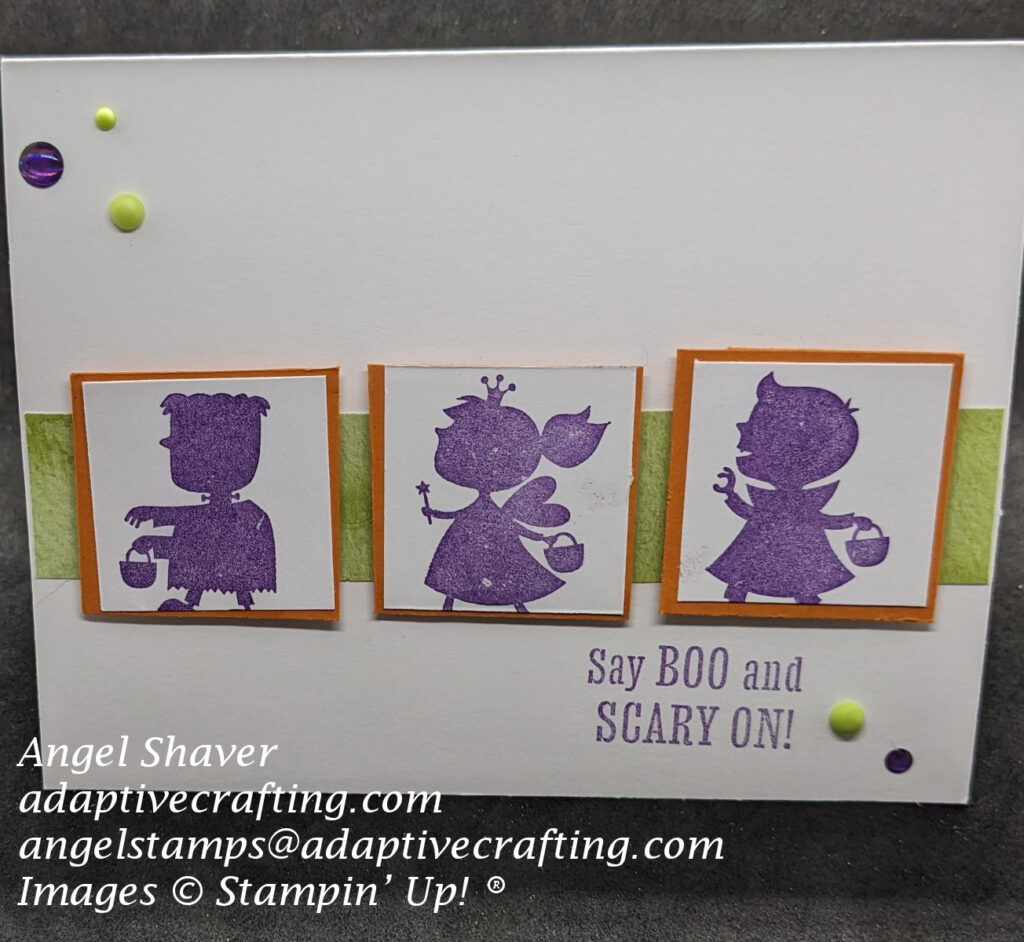 White Halloween card with rectangular strip of green paper across center of card.  Three white squares, framed with orange paper, with costumed trick or treaters stamped in purple are adhered along green paper strip.  Sentiment is stamped in purple and says, "Say Boo and Scary On!"
