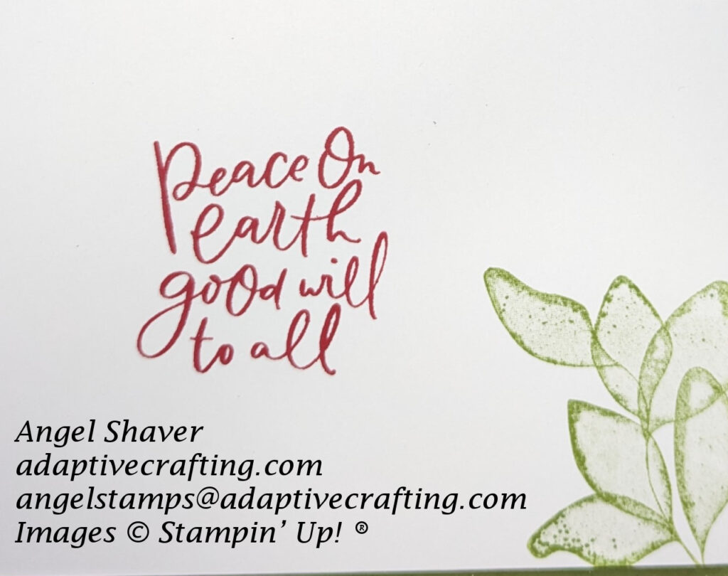 The white inside of the card with stamped green leaf bundle and red sentiment that says, "Peace on earth, Good will to all.