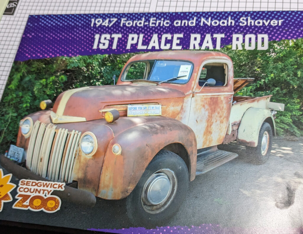 Plaque from Sedgwick County Zoo Car Show that says, 1947 Ford--Eric and Noah Shaver--1st Place Rat Rod.  With picture of the tan truck with lots of rust blooms.