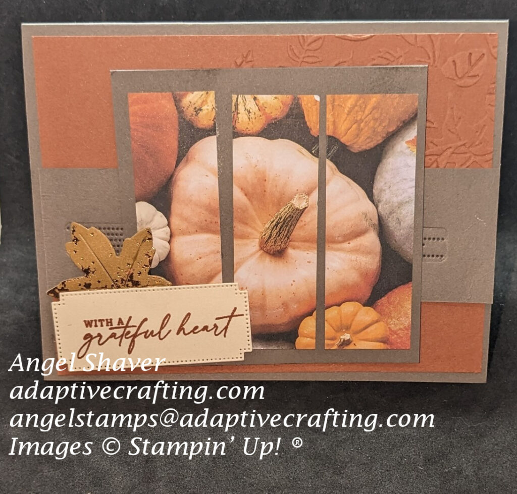 Grayish card with copper clay layer embossed with  falling leaves.  Triptech of pumpkin patterned paper is on top layer along with diecut leaf and sentiment label that says, "with a grateful heart."