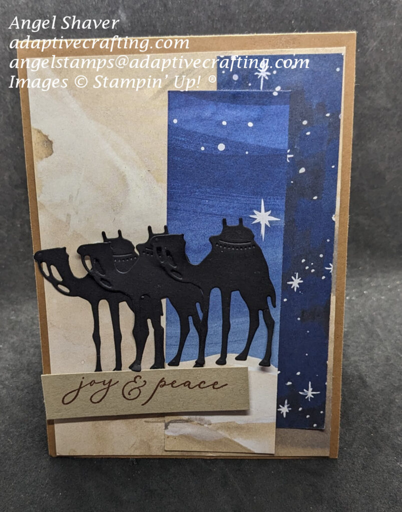 Brown Christmas card with patterned paper representing a sandy dessert and a starry night sky.  There are three camel dies on the front of the card.  The sentiment label says, "joy & peace."