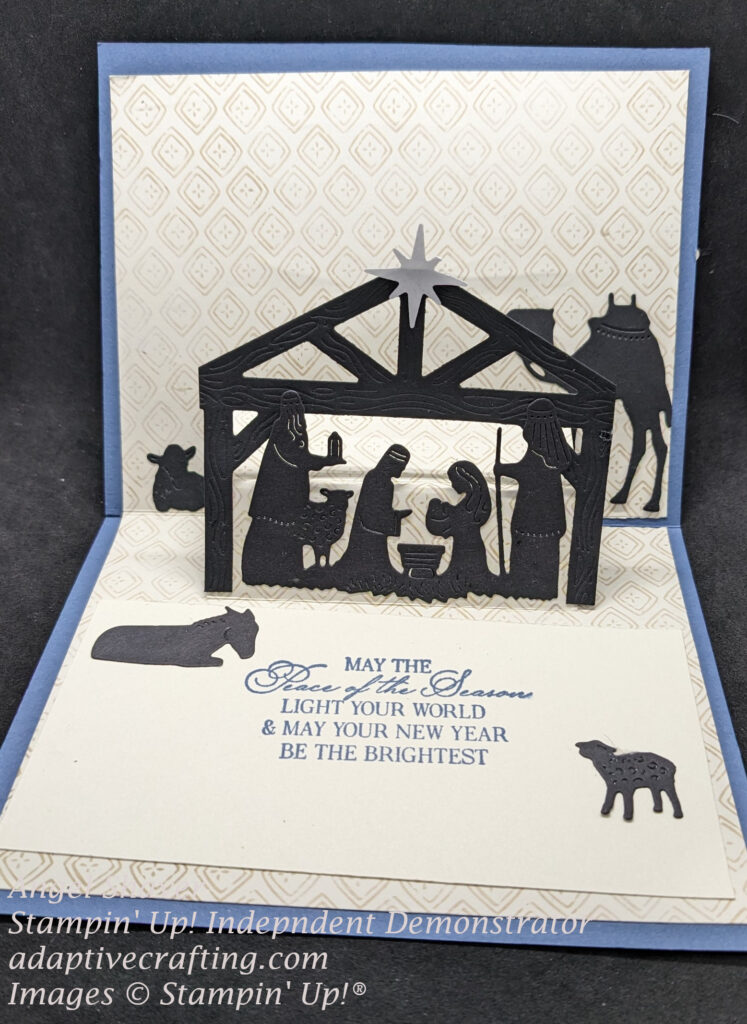 Inside of card shows a pop-up nativity with stable, Holy Family, Shepherd, Wiseman, and animals.  Sentiment says, "May the peace of the season light your world & may your new year be the brightest."