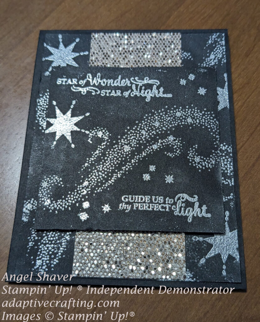 Black card with silver heat embossed stars on background layer and top focal square.  Includes strip of sequined glimmer paper.  Sentiment says, "Star of wonder, star of night . . .Guide us to thy perfect light."