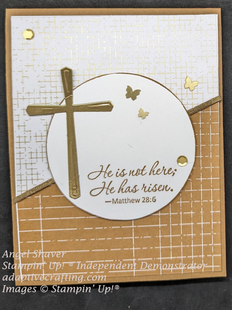 Brown Easter card with white and gold plaid paper on top half of card front and brown and while plaid paper on bottom half.  Gold faux leather ribbon crosses center diagonally between to patterns.  Card center has white circle with Gold cross and sentiment says, "He is not here; He has risen."  Matthew 28:6.  Card is finished with gold sequins and brushed brass butterflies.