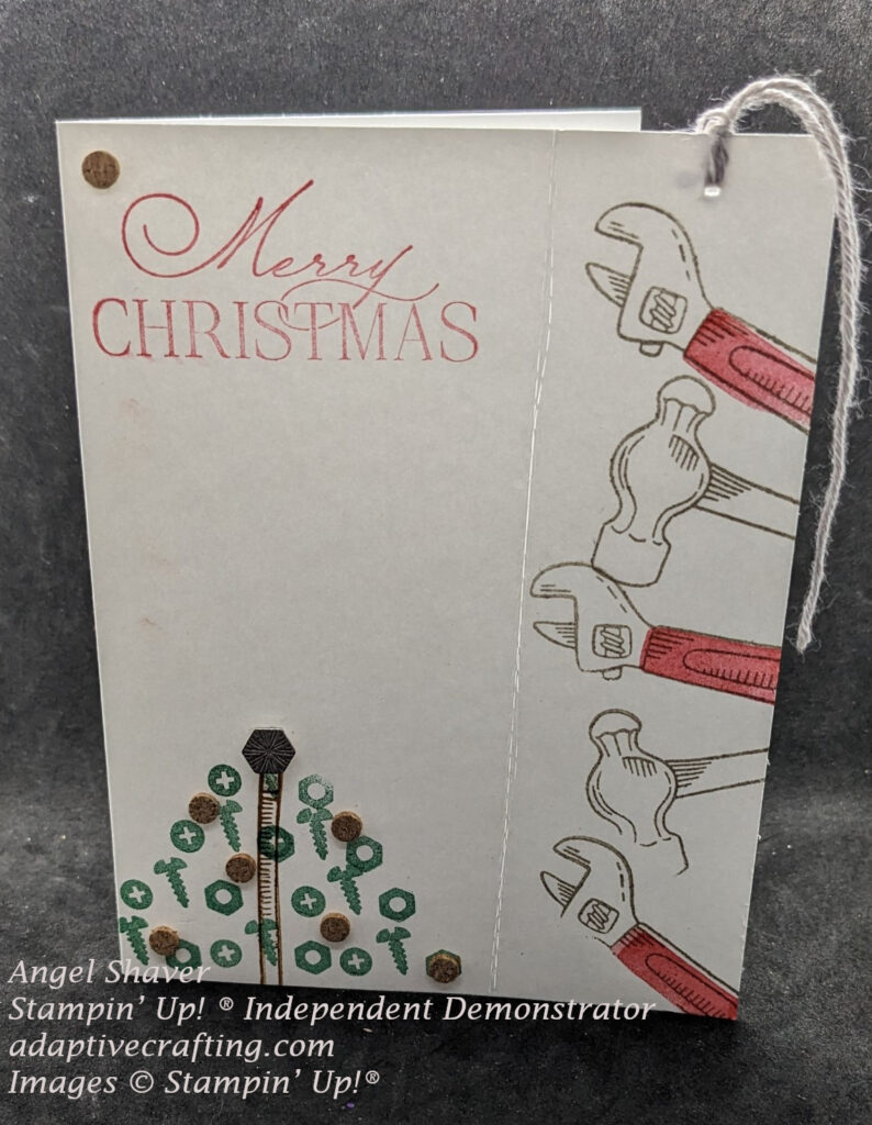 White Christmas card with perforated detachable bookmark on right side stamped with hammers and wrenches.  Bottom of card has Christmas tree made of stamped screws, decorated with cork rounds, with an industrial trinket on top.  Sentiment says, "Merry Christmas"