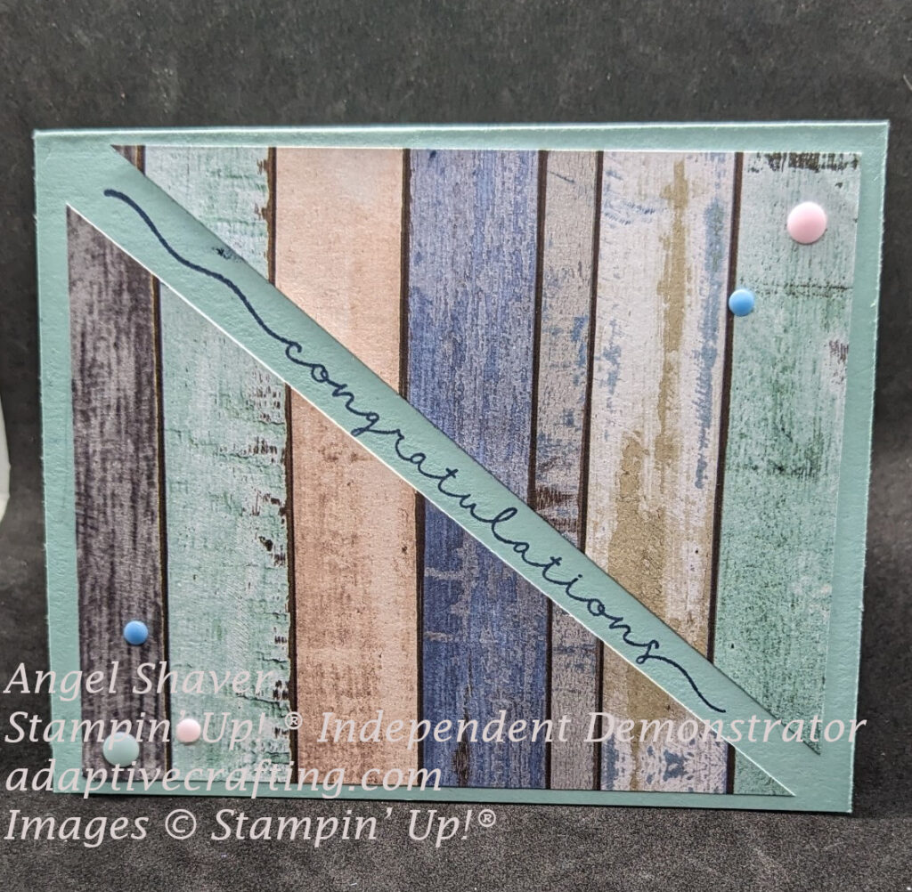 Blue-green card with patterned paper of wood panels in various colors.  The patterned paper rectangle is cut in half diagonally and attached to card with diagonal space  in the middle.  Sentiment "congratulations" is stamped in that diagonal.  Card embellished with colored adhesive dots.