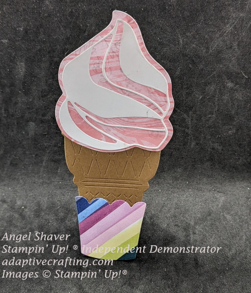Shaped ice cream cone card with pink swirl patterned paper ice cream with while cardstock swirl.  Cone has bright colors diagonal stripes cone holder.