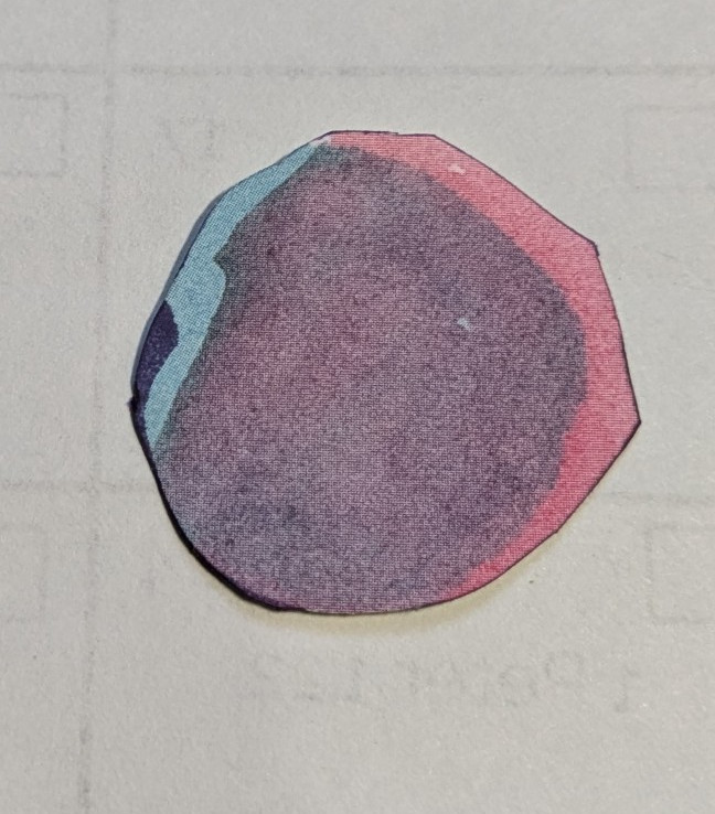 Purple, pink, and blue paper fussy cut into a  citcle.
