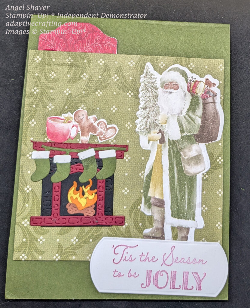 Green Christmas card with front panel that looks like green and white wallpaper sets background for Christmas scene.  Vintage Santa wearing green coat and carrying tree and bag of toys stands in front of diecut fireplace with green stockings hung from mantle.  There is a fire in the fireplace and cookies and a hot drink resting on the mantle.  Top of scene has a red patterned paper tab punch.  Bottom of scene has white label with sentiment "'Tis the Season to be Jolly" in red.