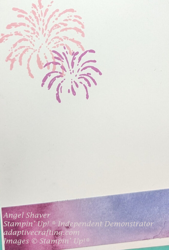 White inside of card with pink and purple fireworks stamped at top left corner.  Strip of pink and purple patterned paper runs along bottom of inside.
