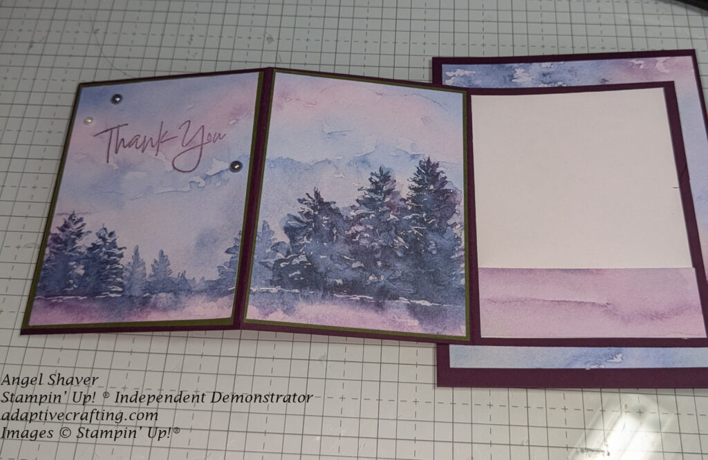 Open card with second panel of patterned paper showing scene of blue and purple sky with forest of dark blue trees.