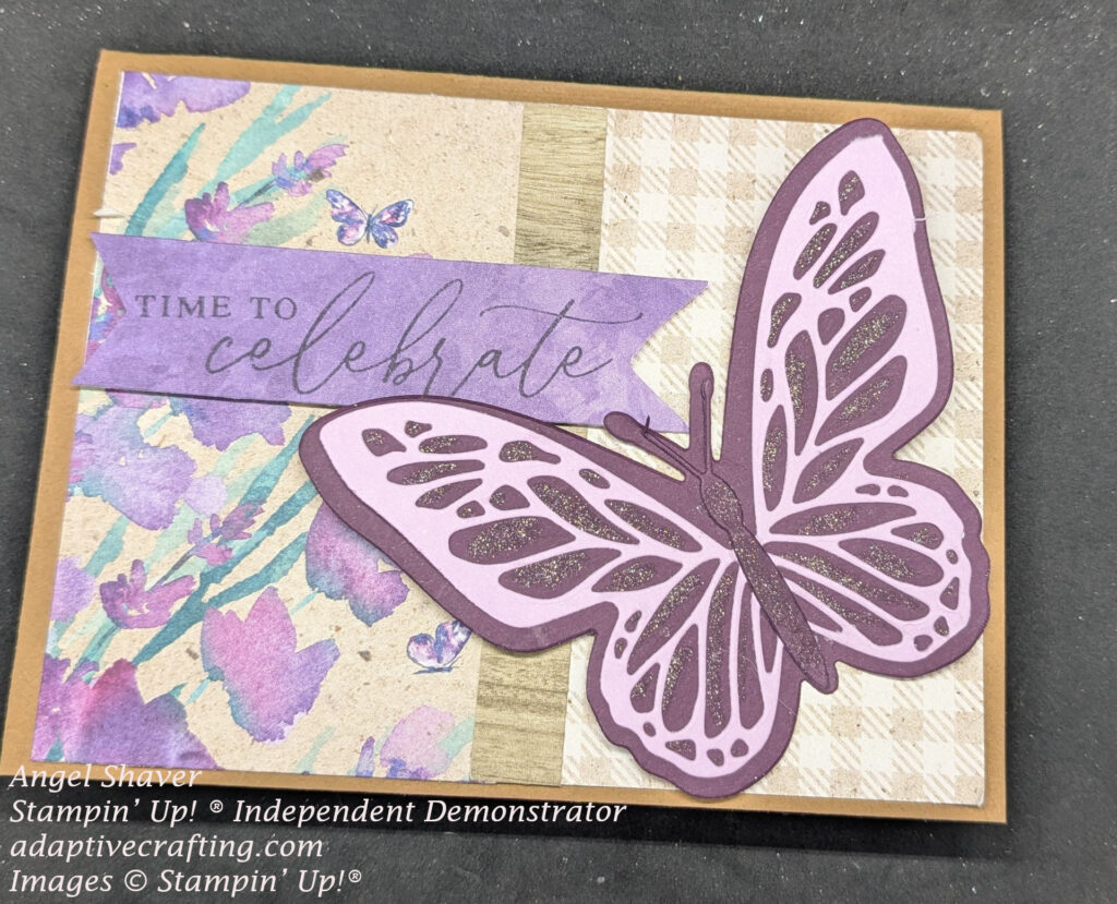 Brown card with patterned paper on the front--half is brown and white plaid and the other side is patterned with purple flowers and butterflies.  There is a strip of wood grain paper between the two patterns.  A large purple butterfly die is on the right side with lighter purple details.  There is a purple sentiment label that says "Time to celebrate."