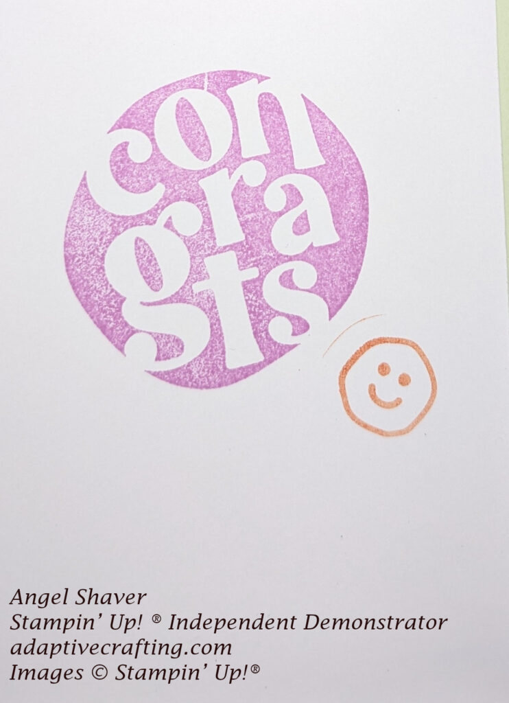 Inside of card with purple circle with white "congrats" in it and an orange smiley face