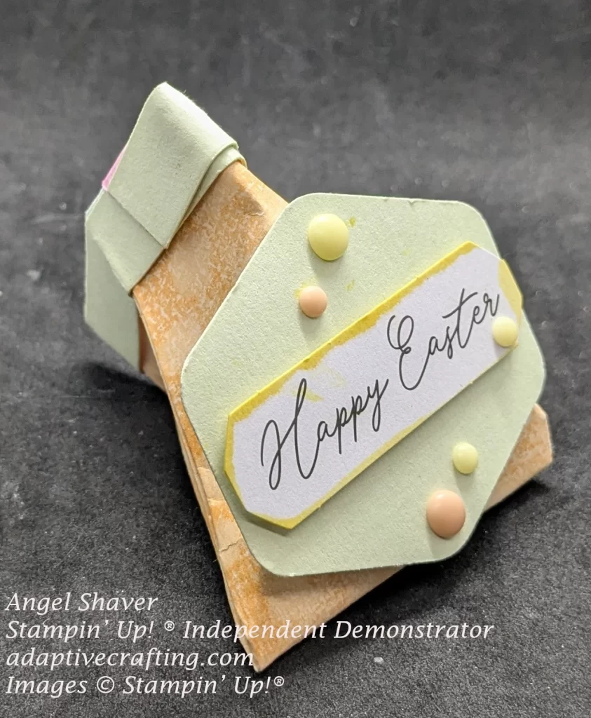 Peach colored treat packaging with light green fold over end. Light green label with "Happy Easter" white label on it with yellow in around sides of white sentiment label. Decorated with peach and yellow dots.