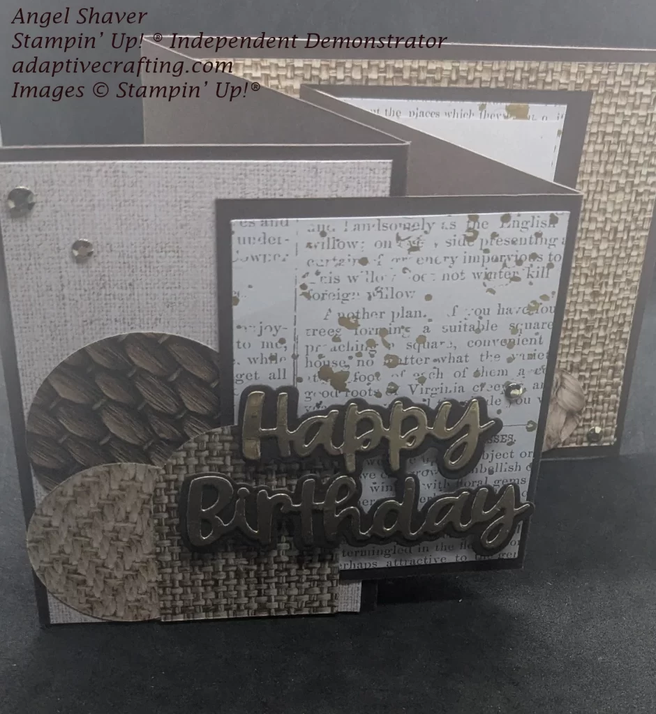 Double Z-gold card standing open,
Brown card with different woven texture patterned papers on larger back z card and cut into circles and an arch. Smaller front z has patterned paper with type splattered with gold Die cut sentiment says "Happy Birthday" in gold foil with a brown background. Gold embellishments decorate the front.