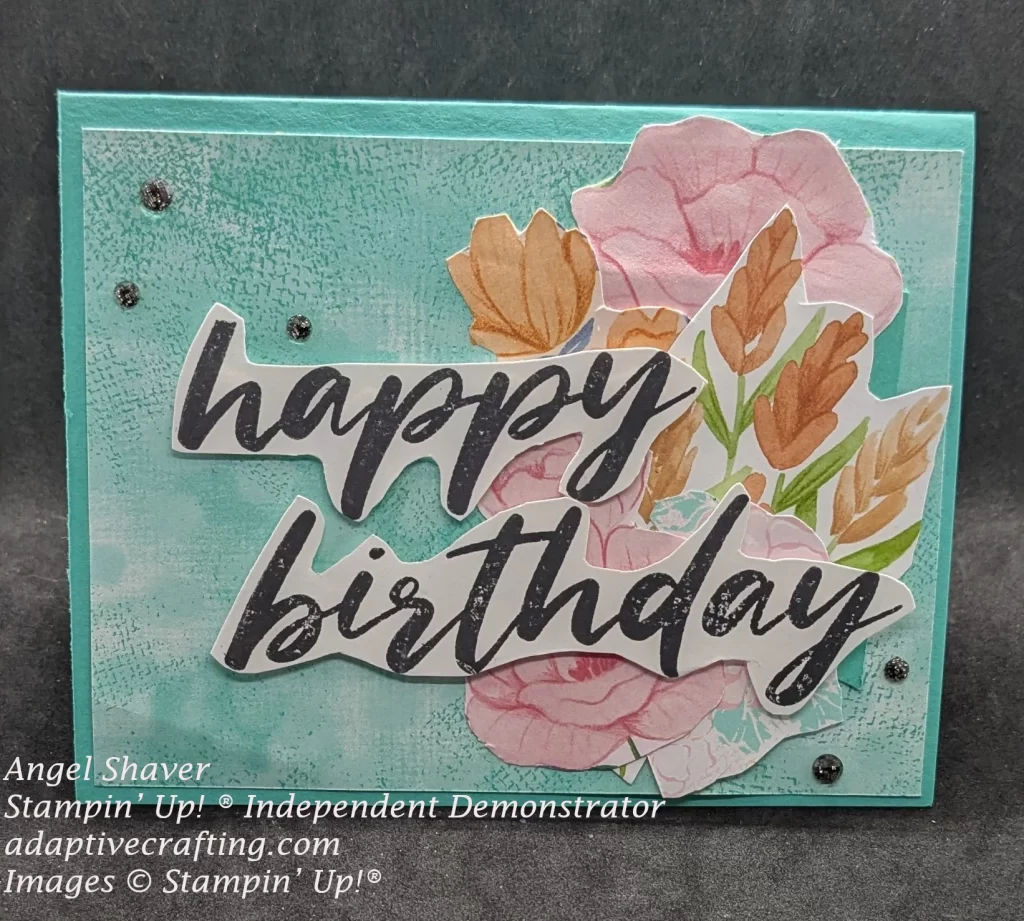Teal card with teal patterned paper layer on front. The is a cluster of flowers cut from Designer Series Paper. Happy Birthday is stamped, cut out around the words and affixed to front of card. Black sparke gems are added.