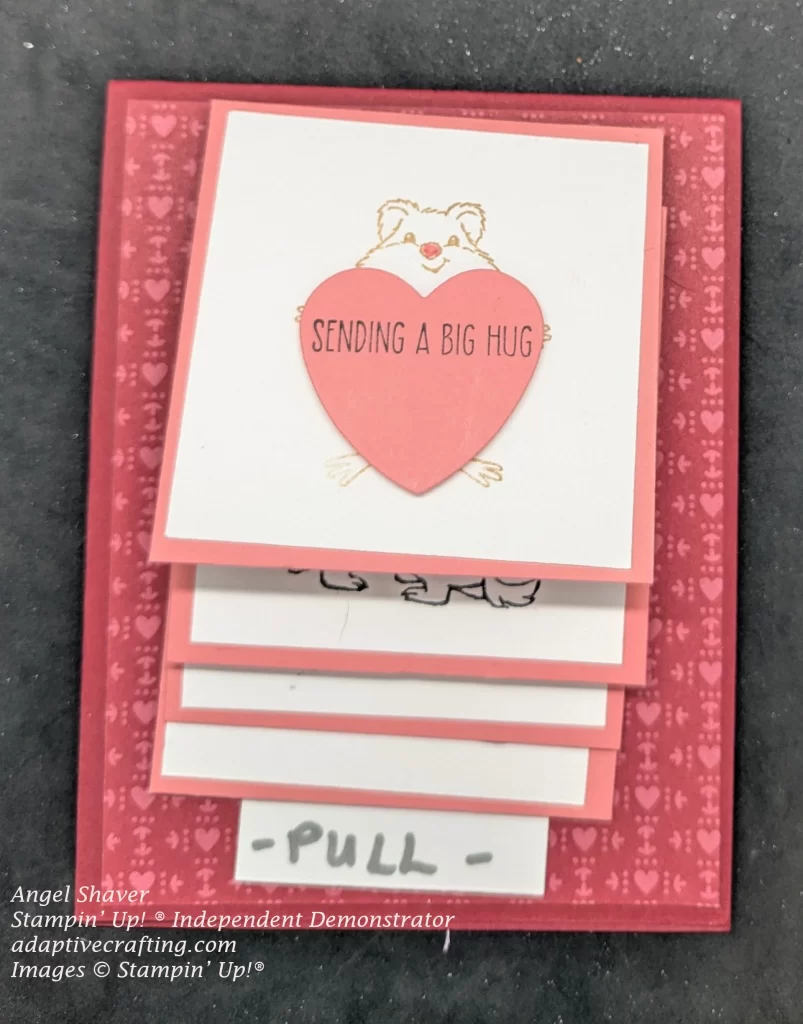 Red waterfall card with red patterned paper with pink hearts.  The waterfall squares were pink.  The first card shows a hamster holding a pink heart that says, "sending a big hug."  The bottom of the waterfall element has a white piece that says, "Pull"