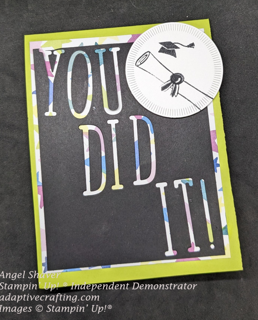 Green card with patterned paper layer with various colors of bright stars.  Black top layer has letters cut out of it to spell, "You Did It!"  White circle die at the top of the page with graduation cap and diplomma.